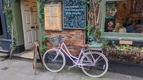 A pink bicycle parked outside a restaurant