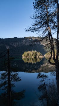 Stunning view of Eibsee with mountain reflections and clear sky in Grainau, Bavaria.