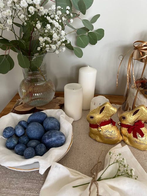A table with a basket of blue eggs and flowers