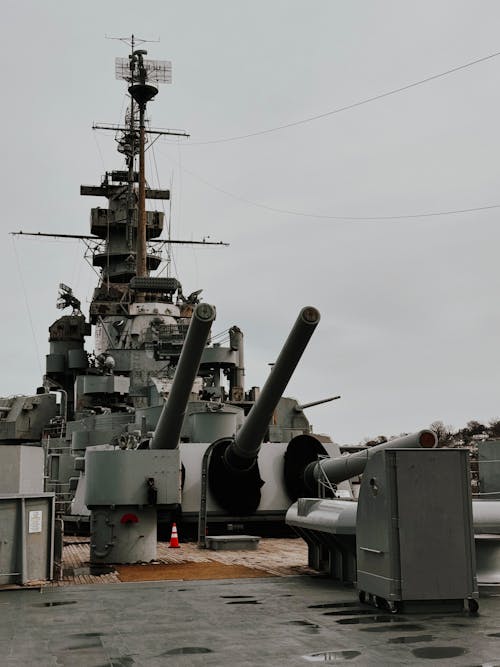 A large battleship sits on the deck of a ship