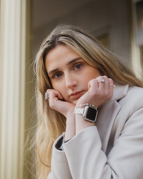 A woman with her hands on her chin and a watch