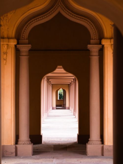 Free A beautifully symmetrical corridor with arches and pillars, inviting a sense of depth and elegance. Stock Photo