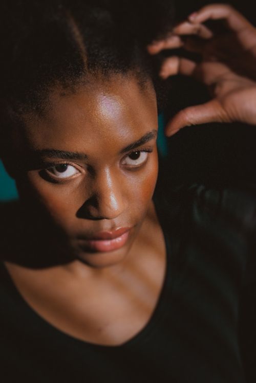 Free Captivating sunlit portrait of a young woman with a dramatic expression, showing intense emotion. Stock Photo