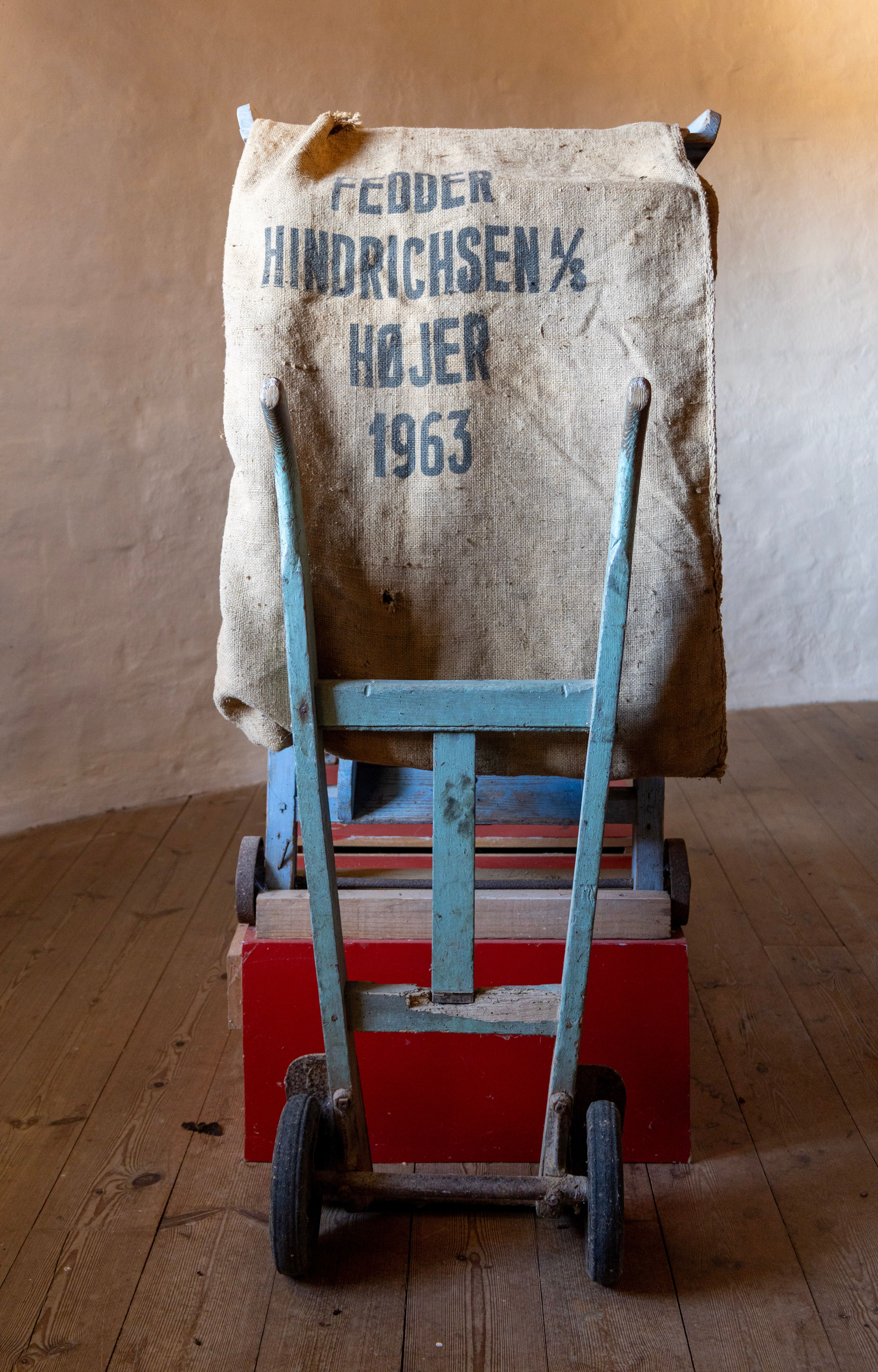 1950s vintage trolley carrying a sack in Højer, Denmark, featuring rustic textures.