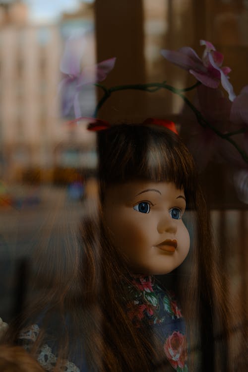 Vintage doll with a reflection on the window. 