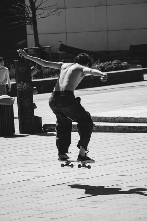 Free Shirtless skateboarder performing a jump on city streets of Istanbul, captured in black and white. Stock Photo