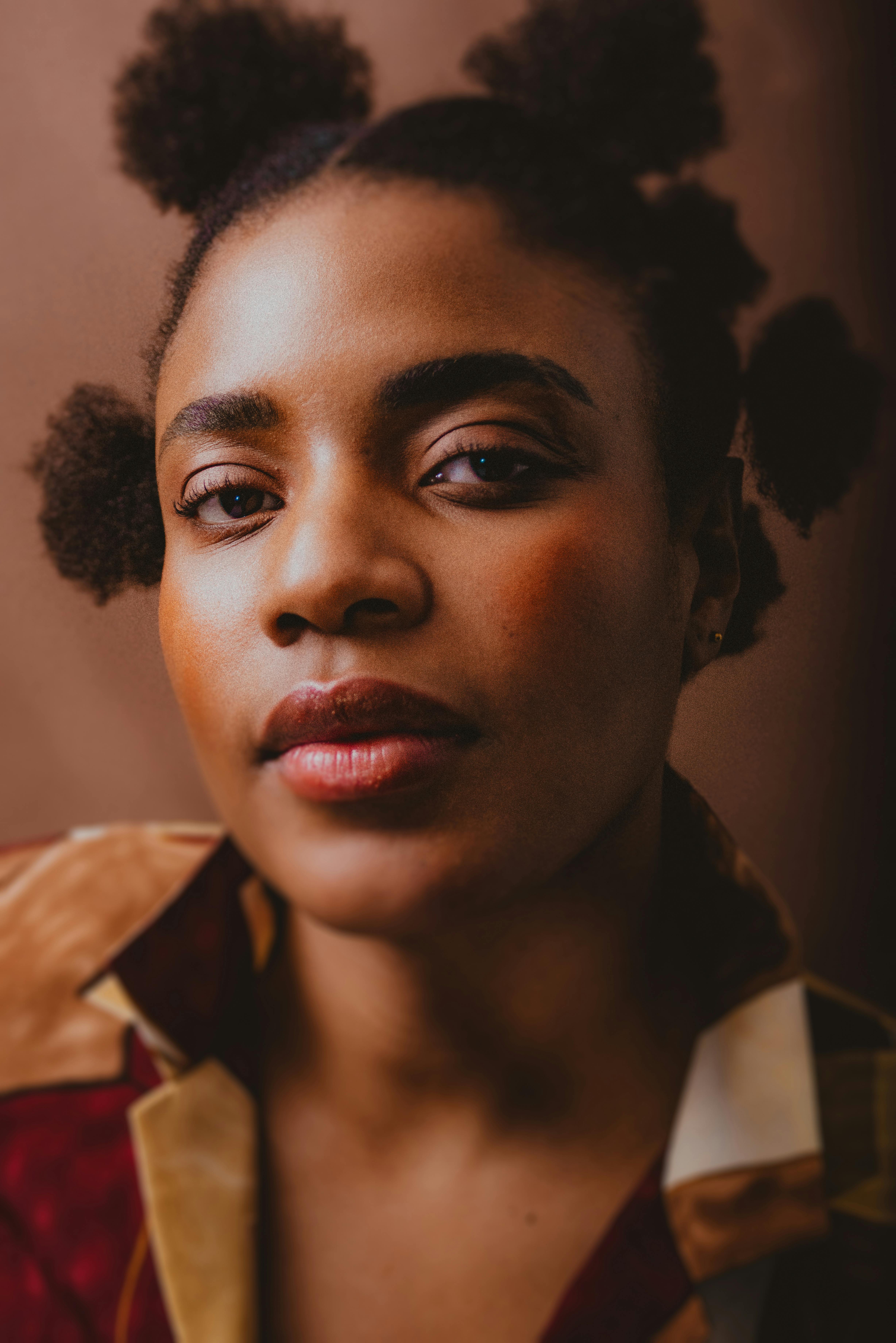 Close-up portrait of a woman with natural hairstyle, exuding confidence and style.