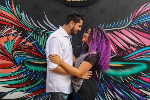 Couple Smiling Near Wall Art Work