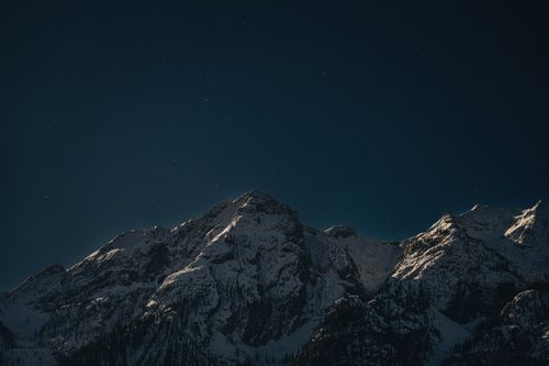 Free Stunning nighttime view of snow-capped mountains under a starry sky, perfect for nature lovers. Stock Photo