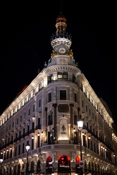 Captivating night view of the iconic Metropolis Building in Madrid, beautifully lit against the dark sky.