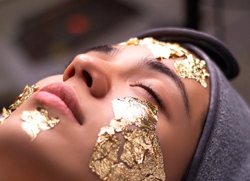 Woman with Foil with Skin Care Cosmetic on Face