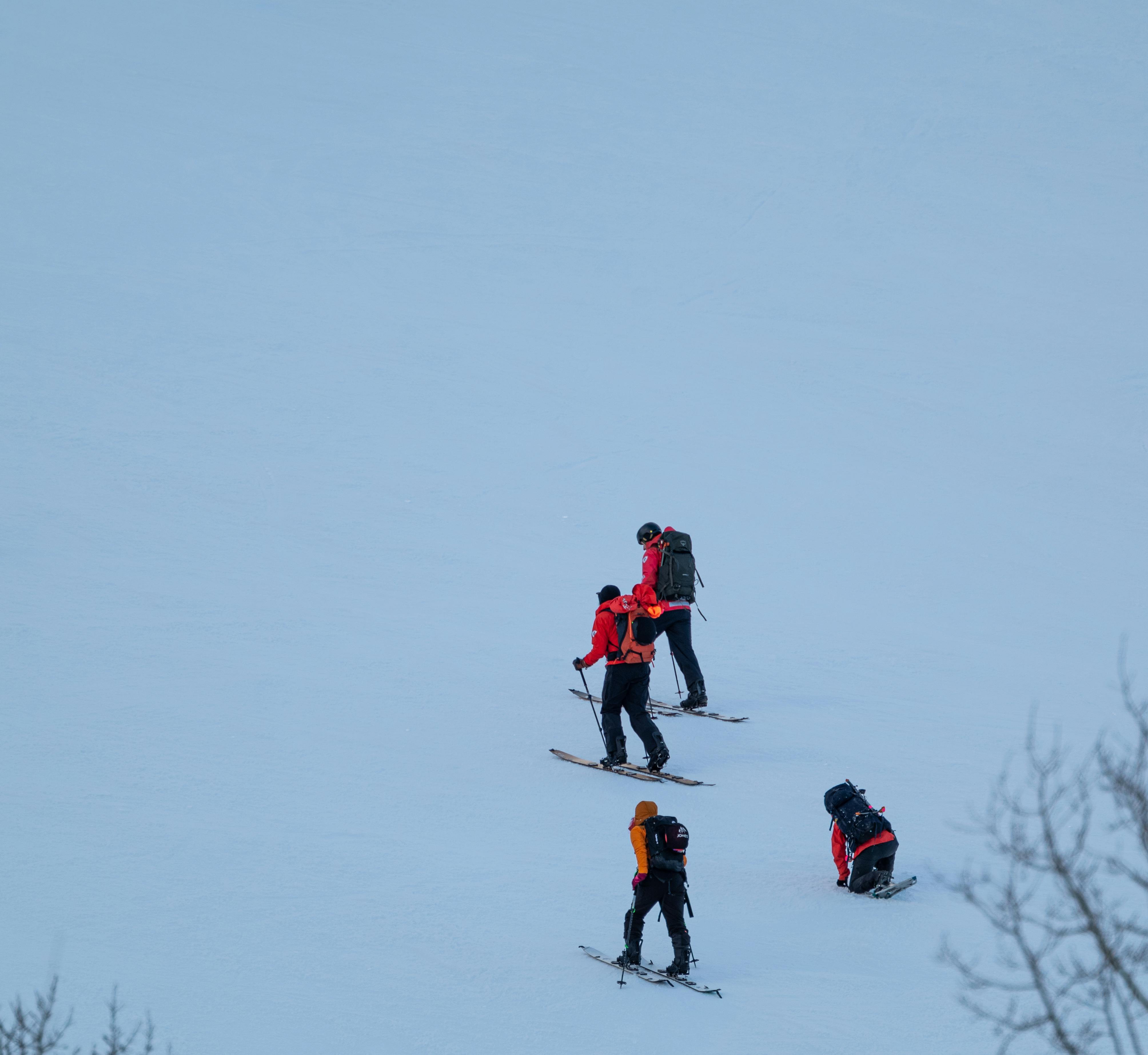 Prescription Goggle Inserts - A group of adults skiing uphill in a snowy winter landscape, showcasing outdoor adventure.