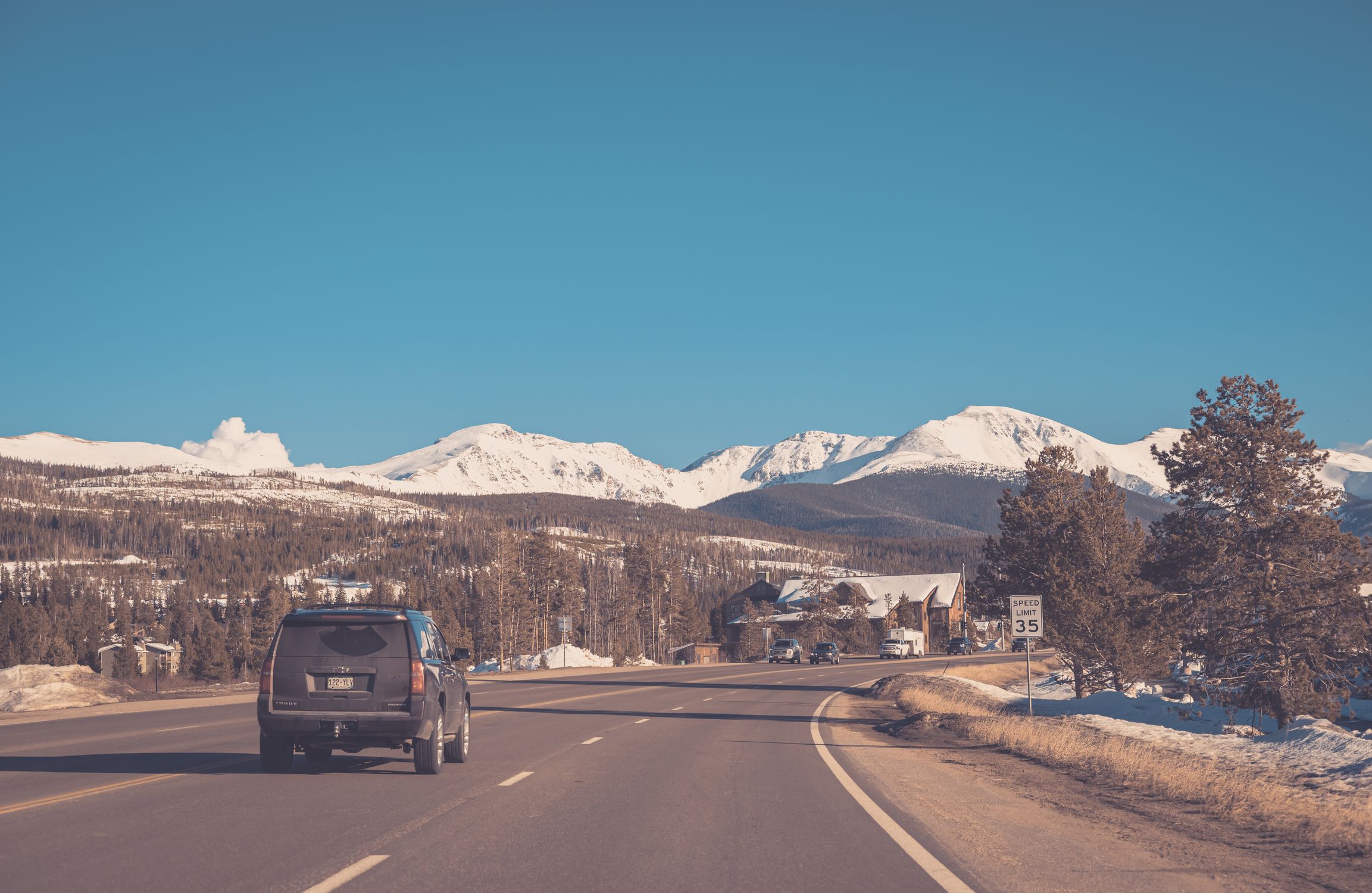 Back View of a Car Traveling Towards the Rocky Mountains · Free Stock Photo