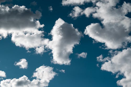 A blue sky with white clouds and a heart shape
