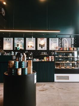 Cozy coffee shop interior featuring counter, menu boards, and a variety of coffee products.
