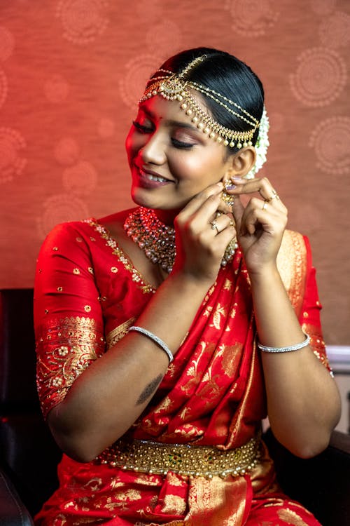 A beautiful indian woman in red sari and gold jewelry
