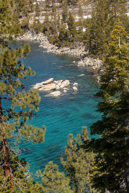 Free Stunning aerial shot of Lake Tahoe surrounded by lush trees and rocky shoreline. Stock Photo