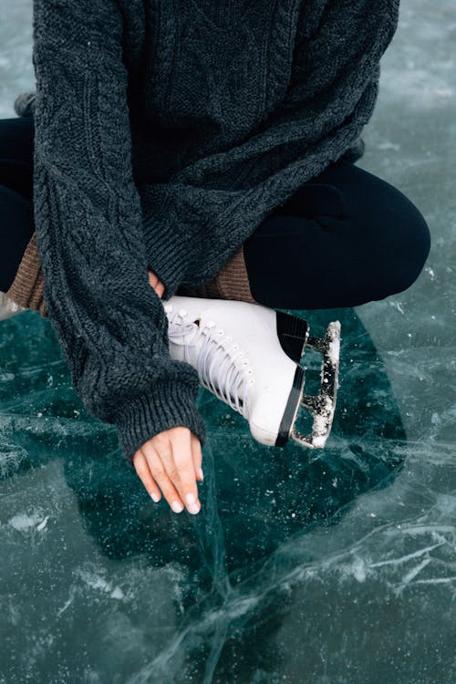 Woman in Ice Skate Sitting on Ice