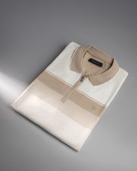 Folded polo shirt on a grey studio backdrop, photo by saeed karimi on Pexels