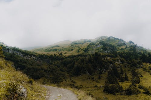 Free A mountain road with a dirt path and a green hill Stock Photo