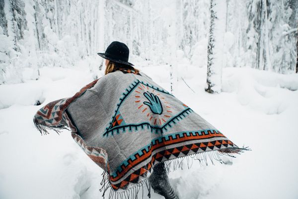 Woman in poncho in snowy forest