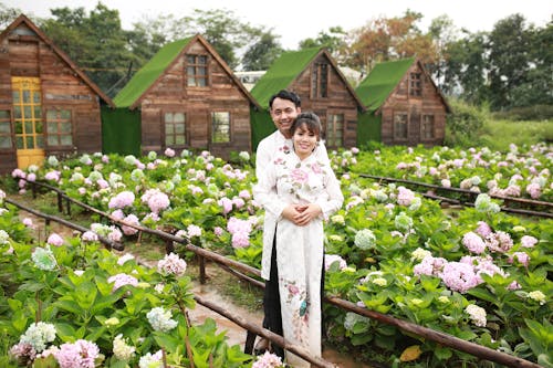 A couple standing in front of a garden with flowers