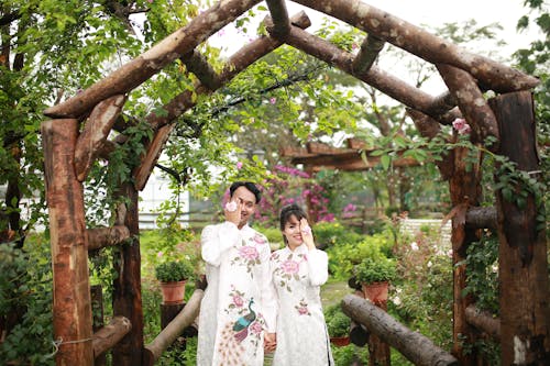 Two people standing in front of a wooden arch