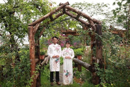 A couple standing in front of a wooden archway