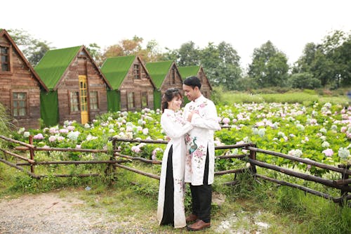 A couple in front of a cabin in the field