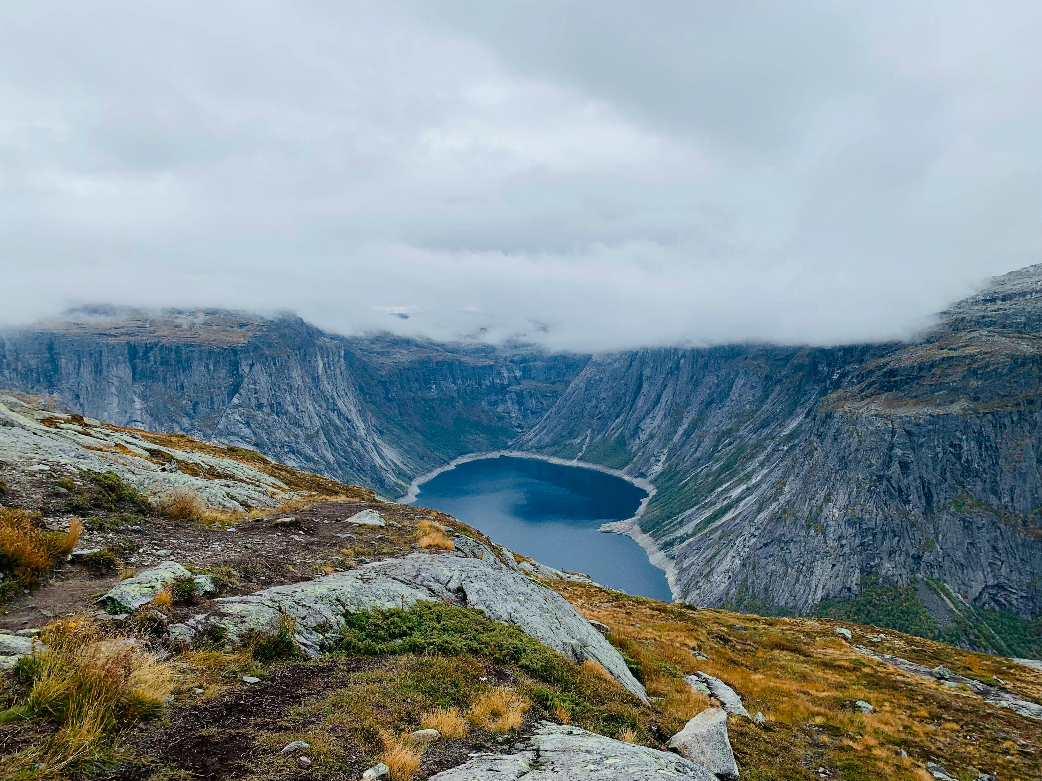 Explore the serene beauty of a Norwegian fjord under an overcast sky in Tyssedal, Vestland.