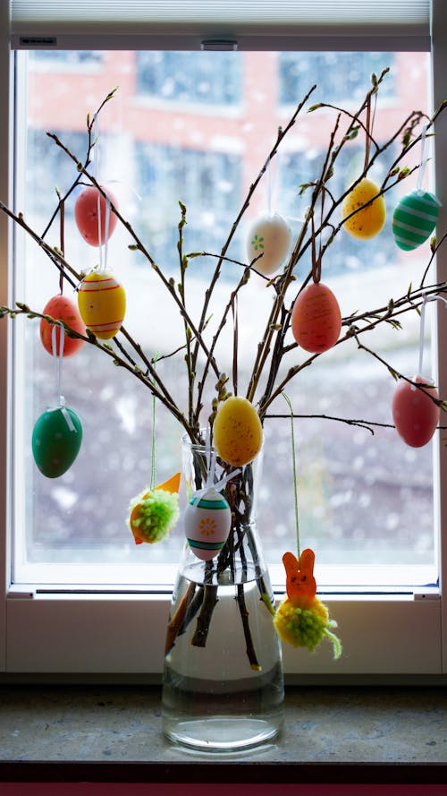 A vase with a bunch of colorful easter eggs