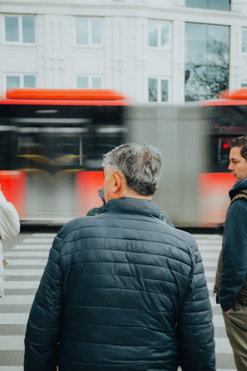 Red Bus in Blurred Motion, and Men Waiting at a Zebra Crossing