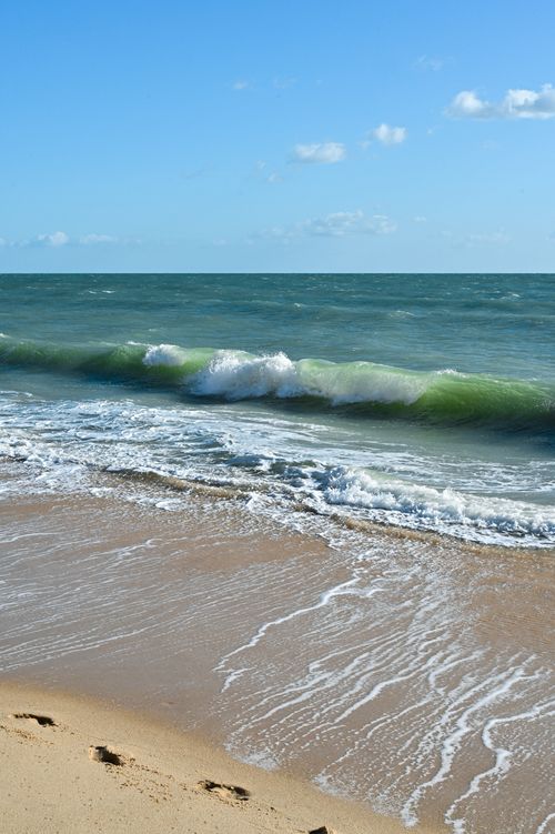 Free Waves crashing against the shore under a clear sky in Albufeira, Portugal. Stock Photo
