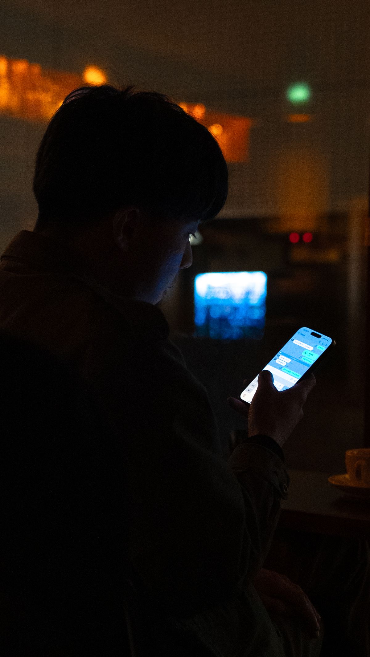 スマートフォンを操作する人物