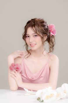 Smiling woman with flowers in her hair, displaying elegance and style.