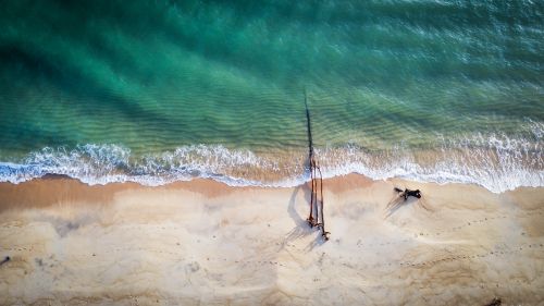 Free Aerial view of a tranquil beach with turquoise waters and golden sand in Terengganu, Malaysia. Stock Photo
