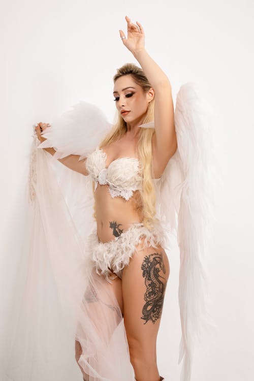 A woman in lingerie with tattoos and wings