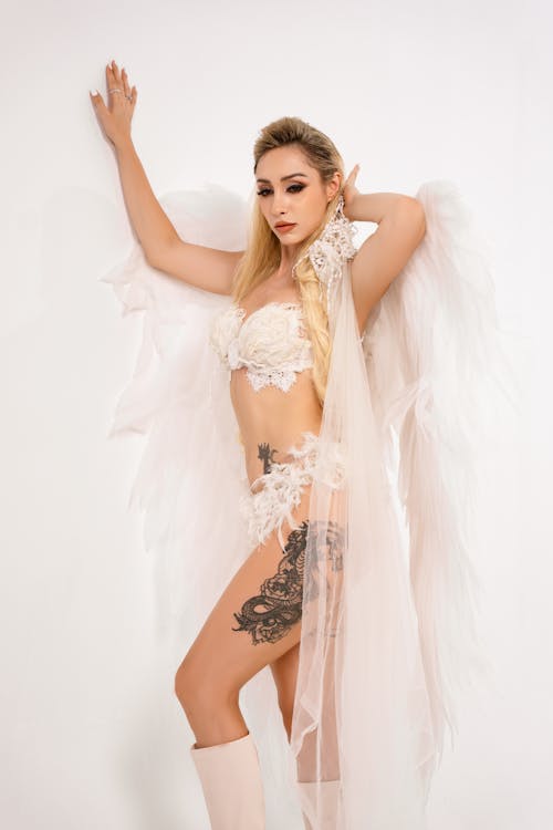 A woman in lingerie with tattoos and wings