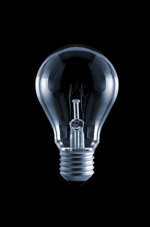 A lit light bulb on black