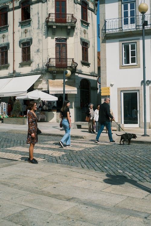 A woman walking down a street with a dog