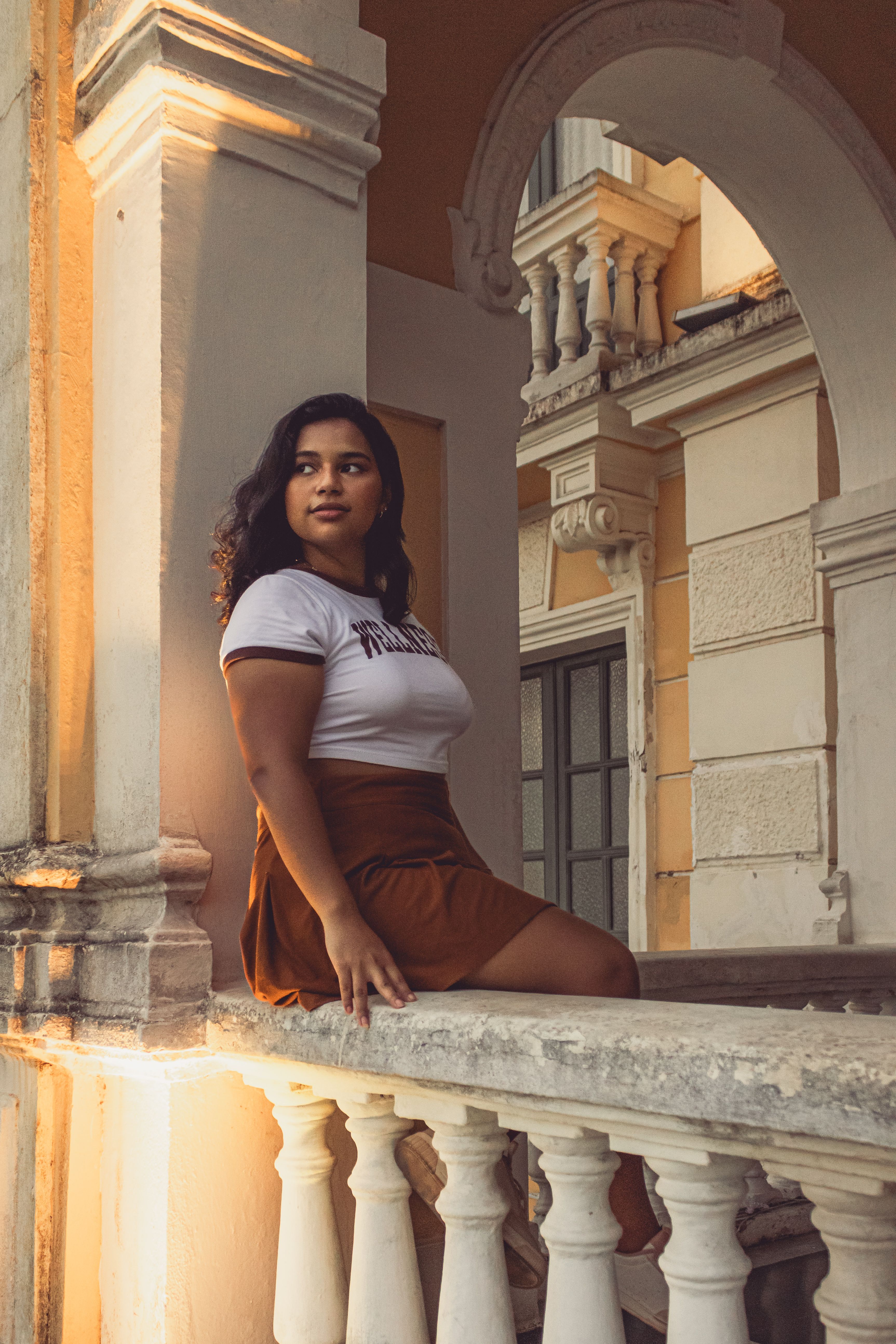 A woman sitting on the railing of a building · Free Stock Photo