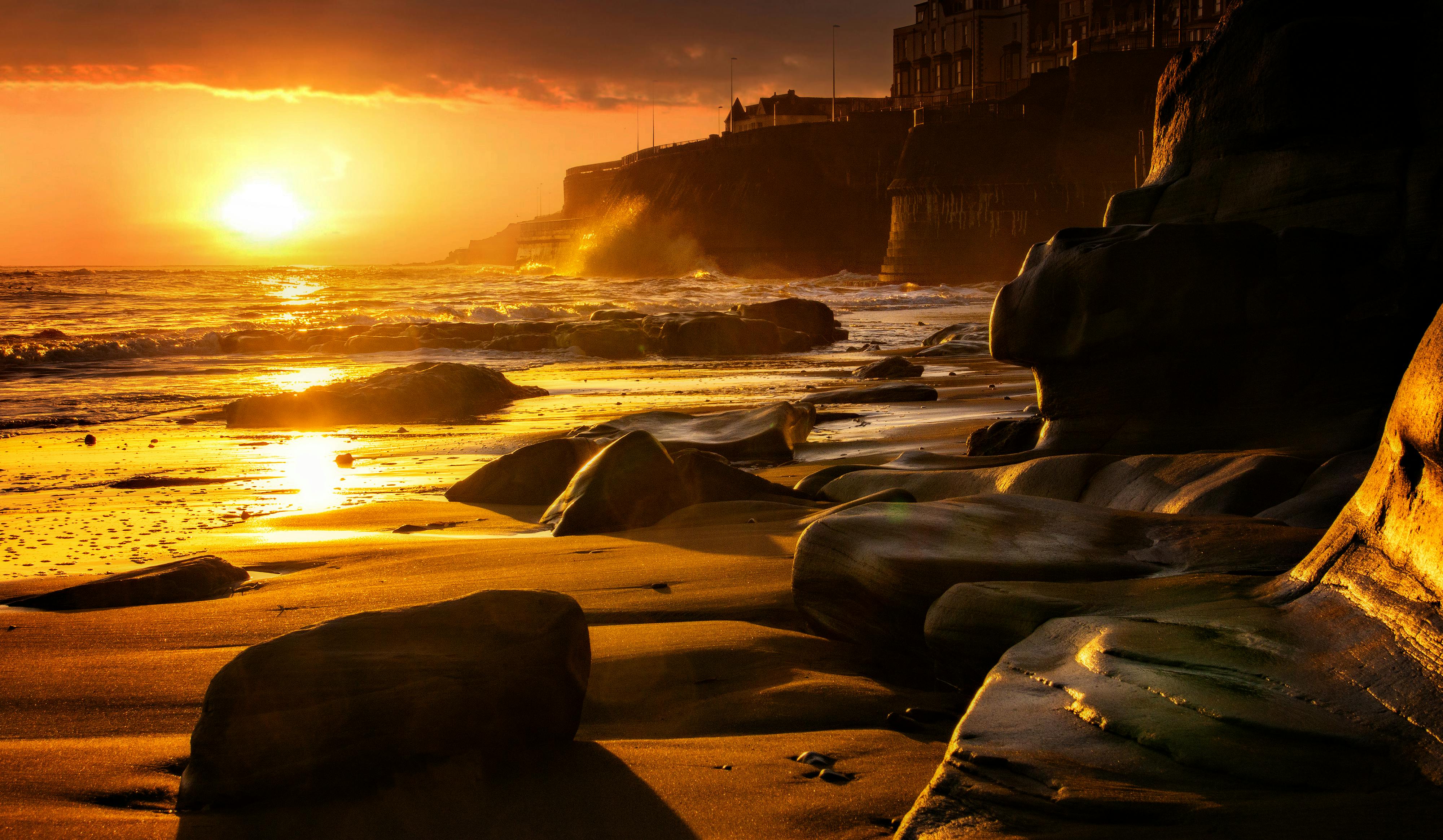 Burriana beach in Nerja with golden sand, crystal water and dramatic rocky cliffs