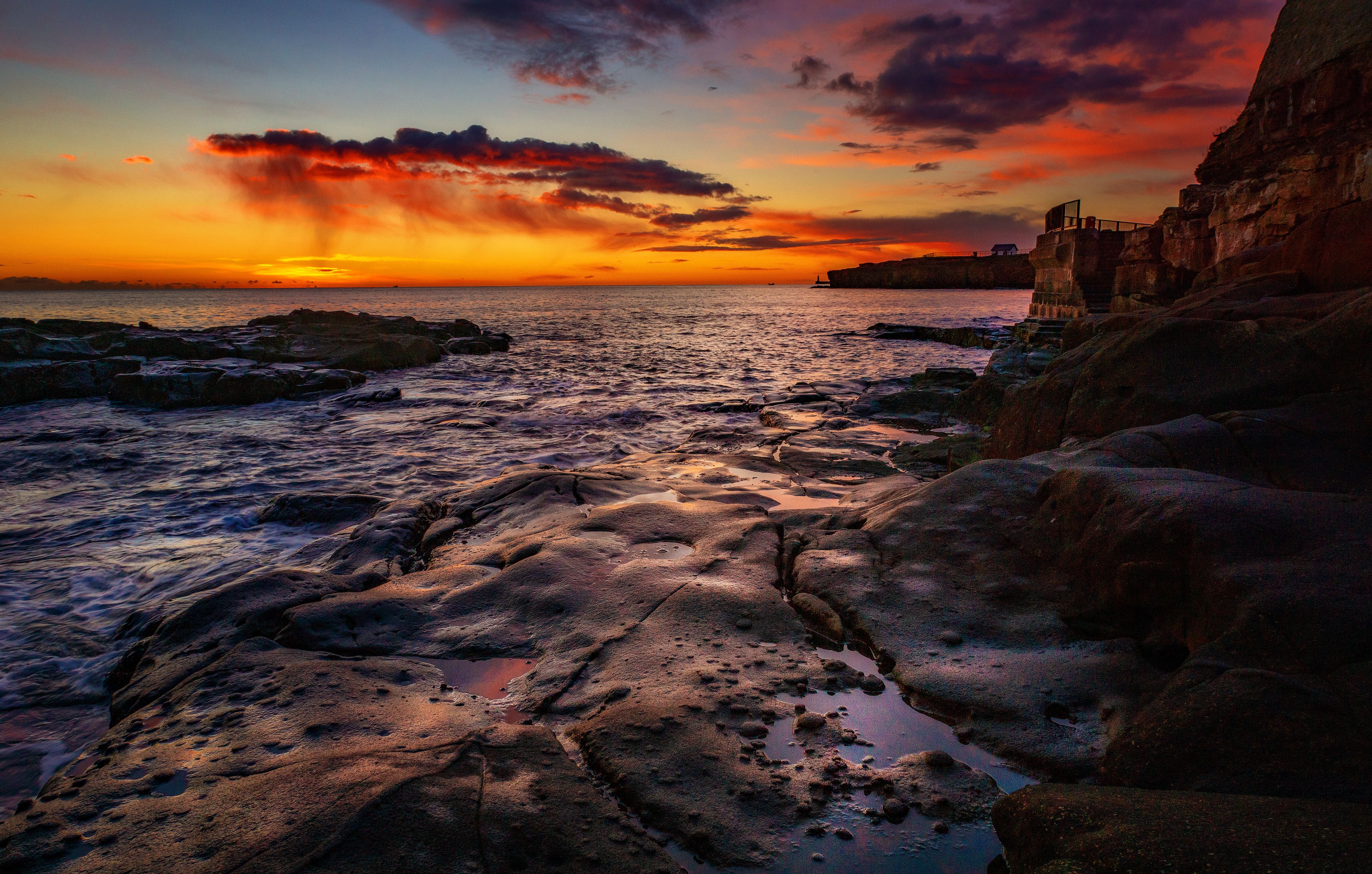 Warm sunset over a calm ocean coastline