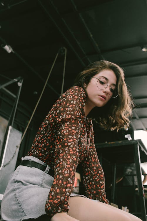 Mujer Vistiendo Camisa De Manga Larga Floral Marrón Y Rosa Con Pantalones Cortos De Mezclilla