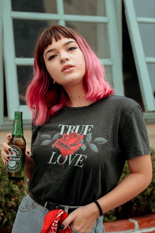 Wanita Memegang Botol Bir Heineken Dekat Gedung