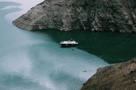在法国普罗旺斯-阿尔卑斯-蔚蓝海岸，一艘宁静的船航行在岩石悬崖环绕的安静海湾中