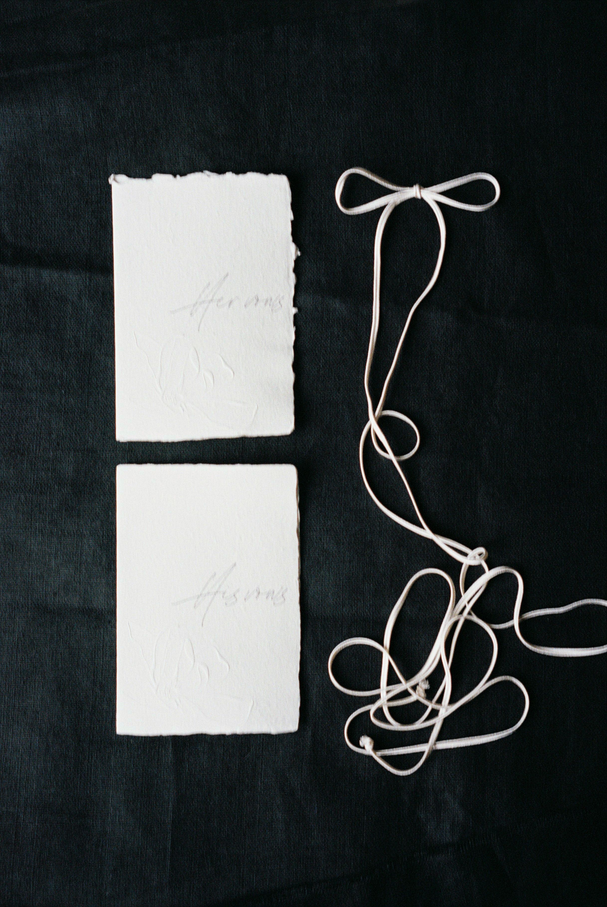 Two white paper cards with string tied to them · Free Stock Photo