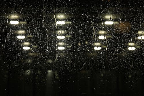 Rain drops on a window in a dark room