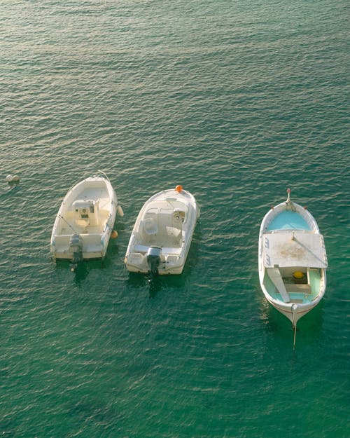 Three small boats are floating in the water