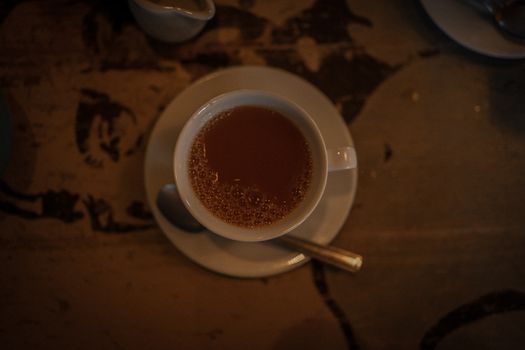 Warm and moody image of a tea cup on a rustic table, perfect for cozy themes.